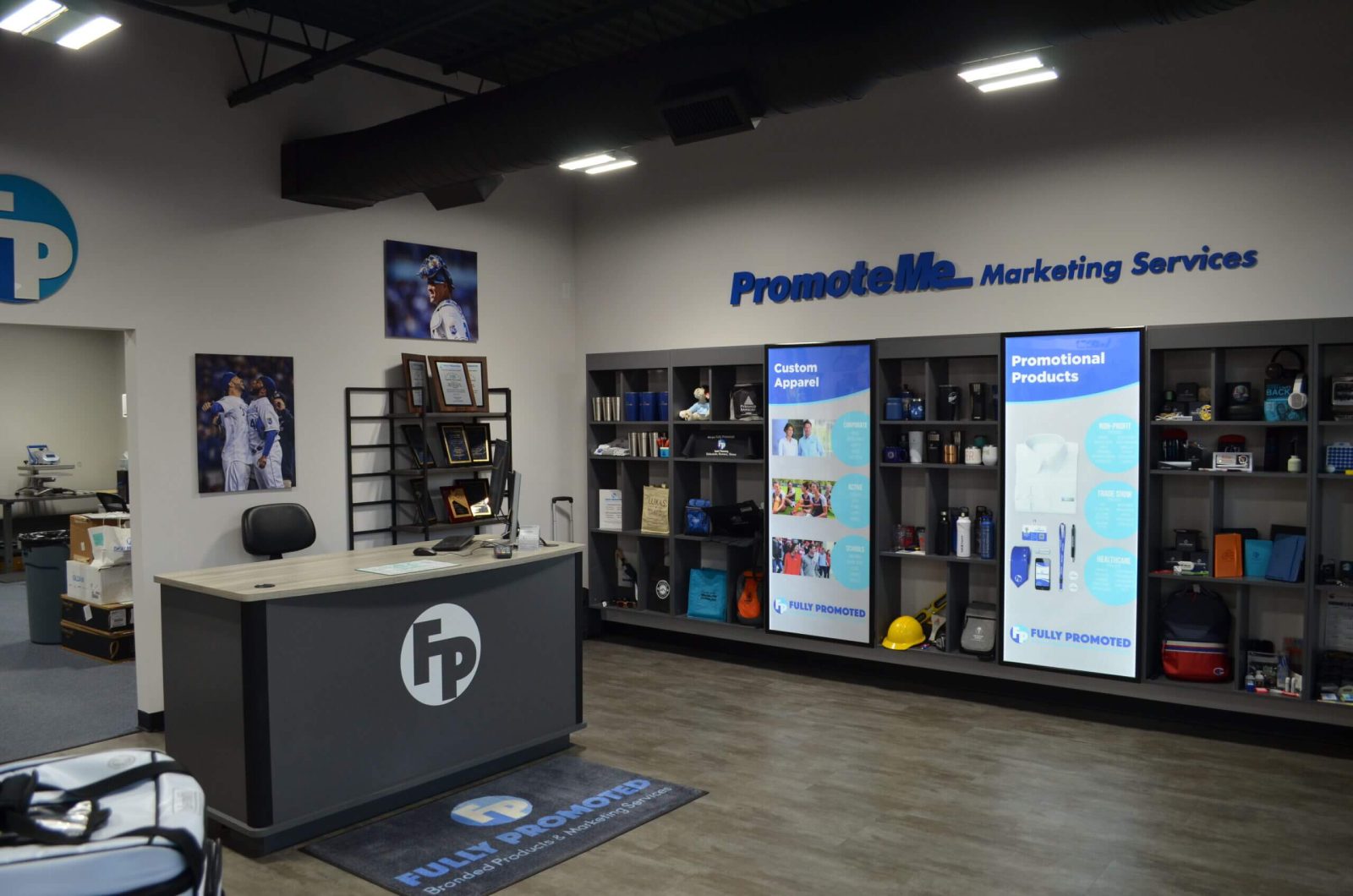 A marketing services office featuring a reception desk, product displays on shelves, and promotional posters on the walls. Illuminated signs and framed photos add to the decor. A marketing services office featuring a reception desk, product displays on shelves, and promotional posters on the walls. Illuminated signs and framed photos add to the decor.