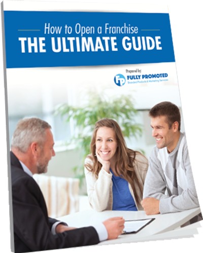 Three people sit at a table, one with a booklet titled "How to Open a Franchise: The Ultimate Guide" by Fully Promoted. Three people sit at a table, one with a booklet titled "How to Open a Franchise: The Ultimate Guide" by Fully Promoted.