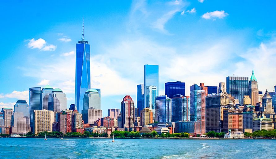 Skyline of New York City with a clear blue sky, featuring the One World Trade Center and various other skyscrapers across the waterfront. Skyline of New York City with a clear blue sky, featuring the One World Trade Center and various other skyscrapers across the waterfront.
