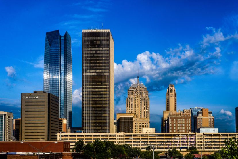 Skyline of a city with several tall buildings under a clear blue sky, featuring modern and historic architecture. Skyline of a city with several tall buildings under a clear blue sky, featuring modern and historic architecture.
